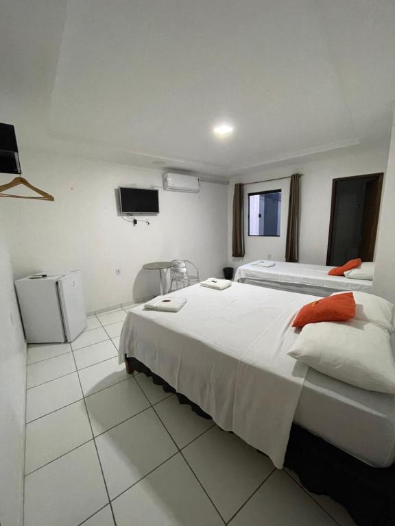 um quarto de hotel com duas camas e uma televisão em Hotel Pousada Acauã Acesso através de escadas em Campina Grande