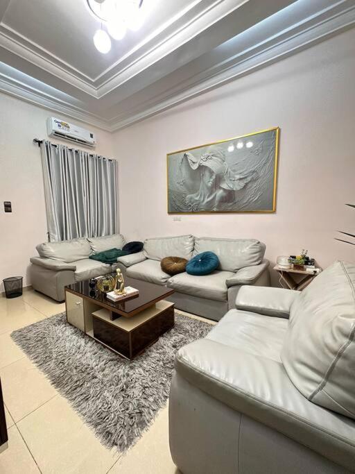 a living room with white couches and a table at Quick Apartments in Cotonou