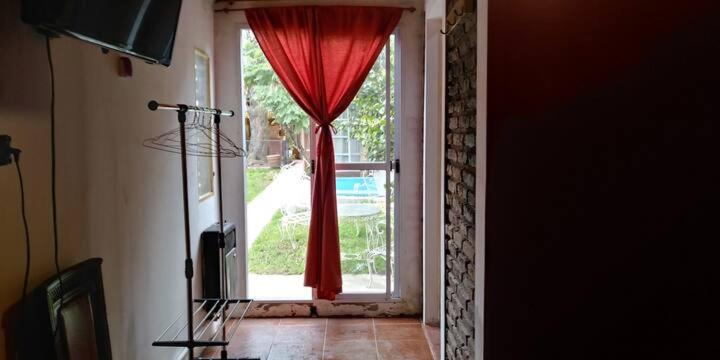 Mariano J. Haedo的住宿－Casa Pato，一间房间里一扇带红色窗帘的敞门