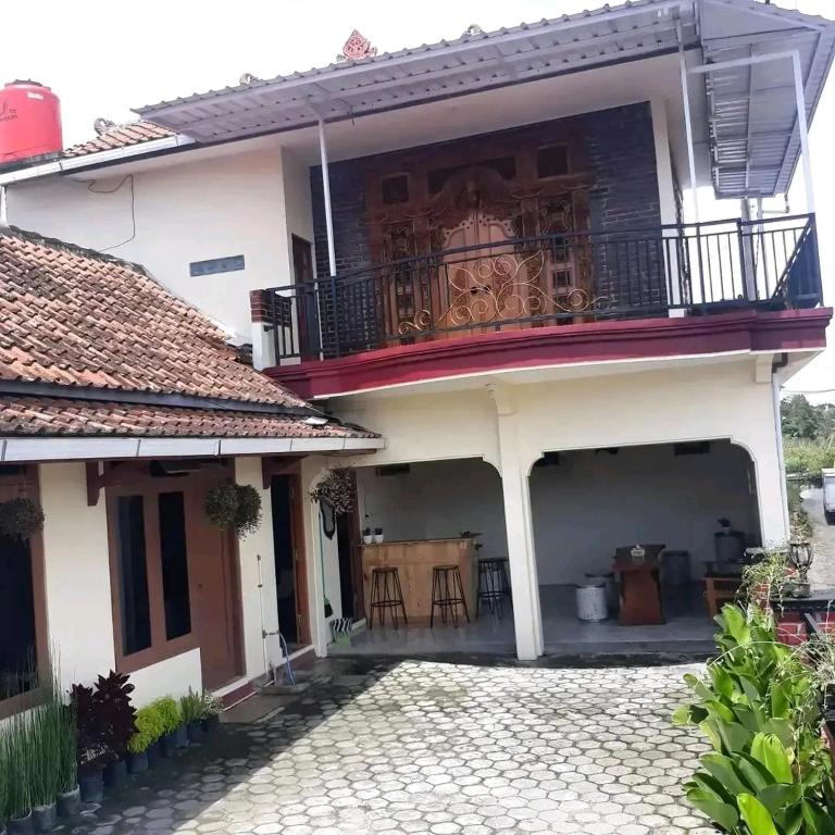 Casa blanca con balcón y patio en MAJA HOUSE 2, en Tambakrejo