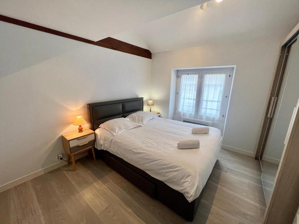 a bedroom with a large bed and a window at Le 46 Magenta - Grand Duplex en hypercentre in Poitiers