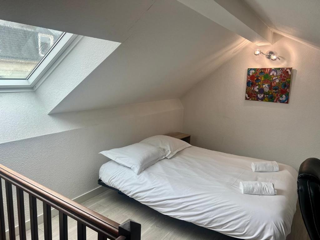 a bed in a attic with a picture on the wall at Le 46 Magenta - Grand Duplex en hypercentre in Poitiers