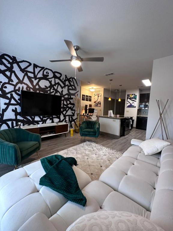 a living room with a white couch and a tv at Stylish-homes in Fort Worth