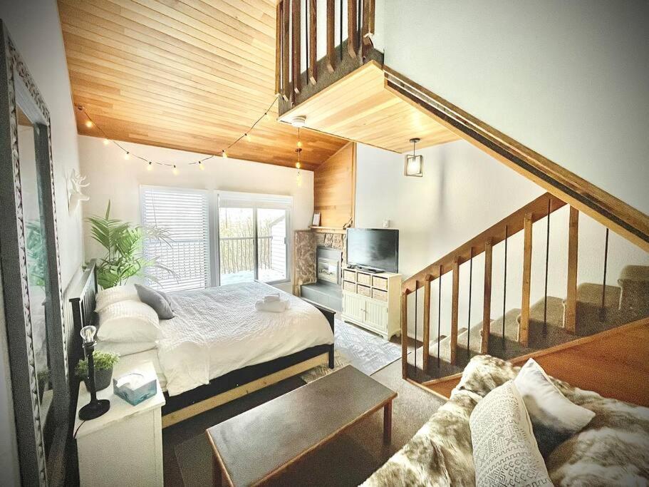 a large bedroom with a bed and a staircase at Mountain Edge in Kimberley