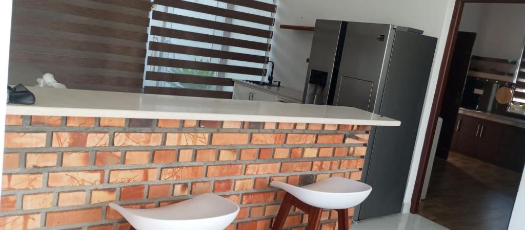 eine Küche mit einer Theke und 2 weißen Stühlen in der Unterkunft Villa Amaya in Negombo