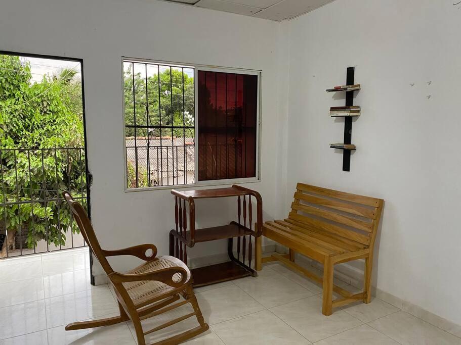 a room with a bench and a table and windows at Hermoso apartamento amoblado in Mompós