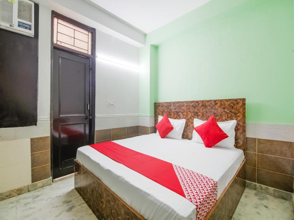 a bedroom with a bed with red pillows at OYO Flagship Hotel Green Light in New Delhi