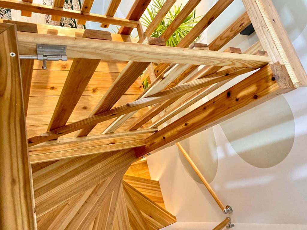 a wooden staircase in a house with a wooden ceiling at Hotel Little Swiss House in Motobu