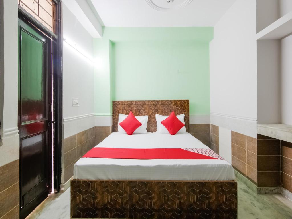 1 dormitorio con 1 cama con almohadas rojas en OYO Flagship Hotel Green Light, en Nueva Delhi