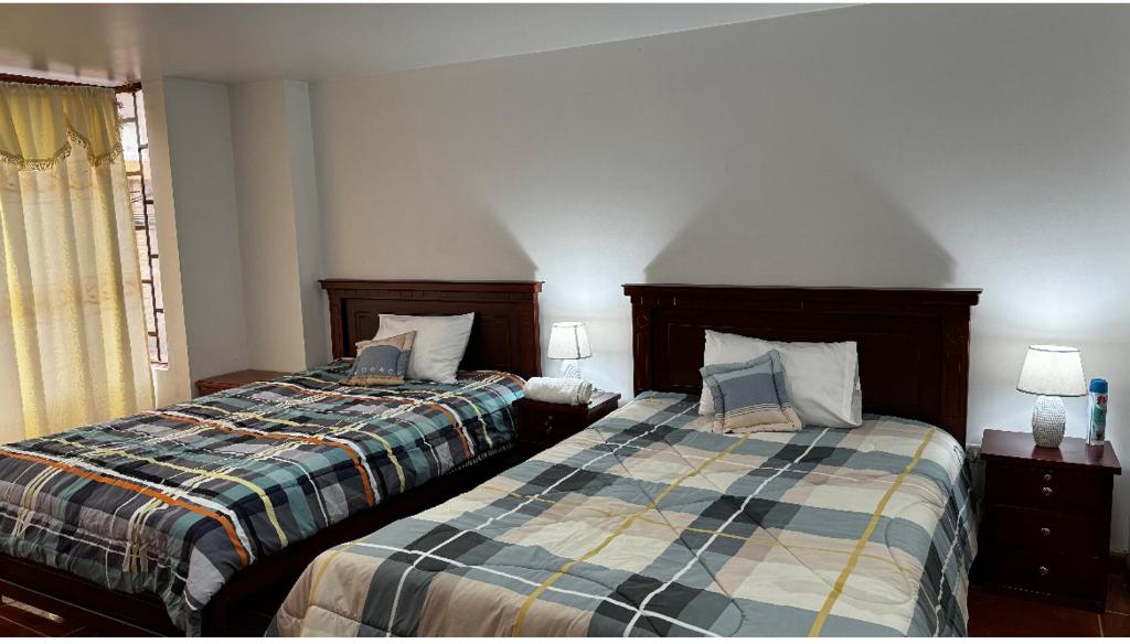 um quarto com 2 camas e uma janela em Kimsa Wasi I em Otavalo