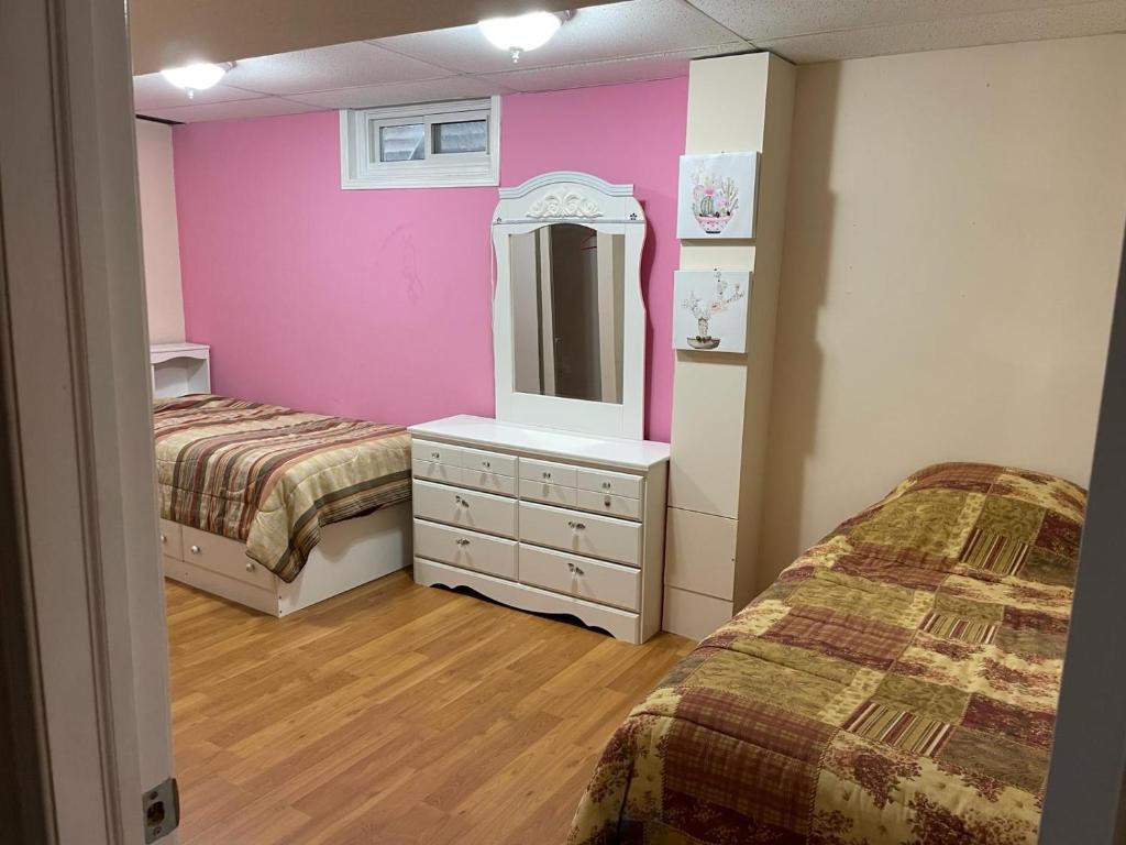 a room with two beds and a dresser with a mirror at Cute 2 beds room , for females only in Ottawa