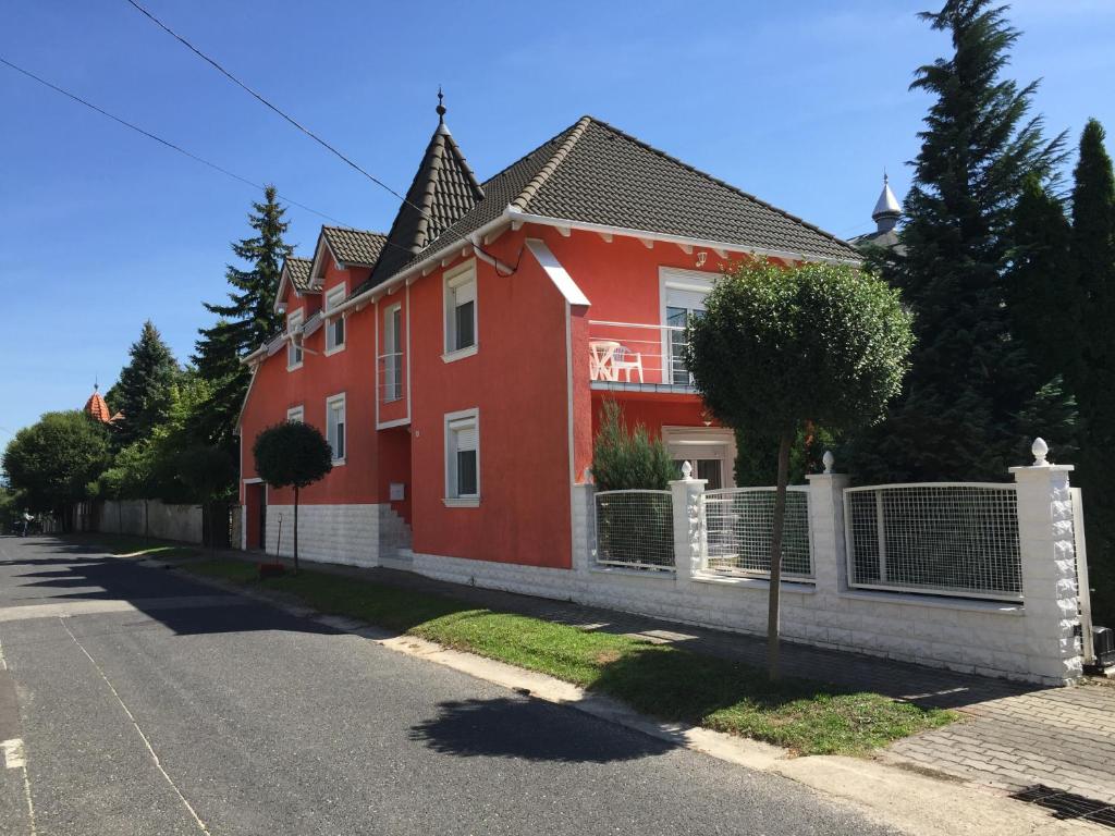 uma casa vermelha ao lado de uma rua em Green Park Apartment em Hévíz