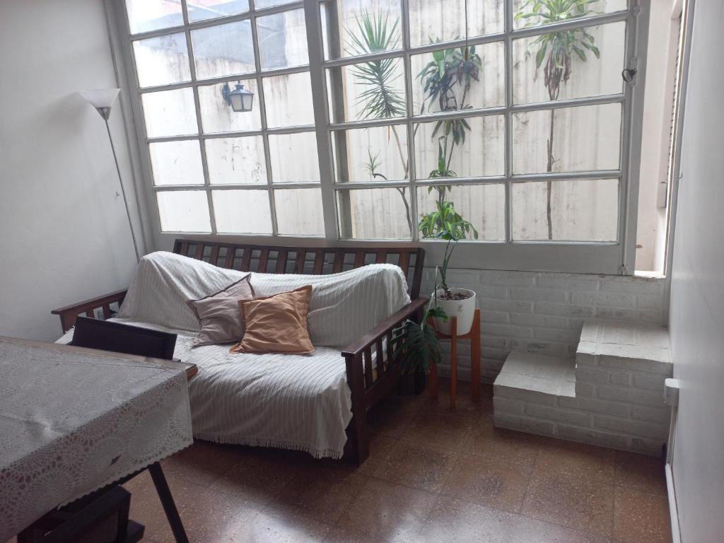 um quarto com um sofá e uma grande janela em Casa grande y céntrica em San Miguel de Tucumán
