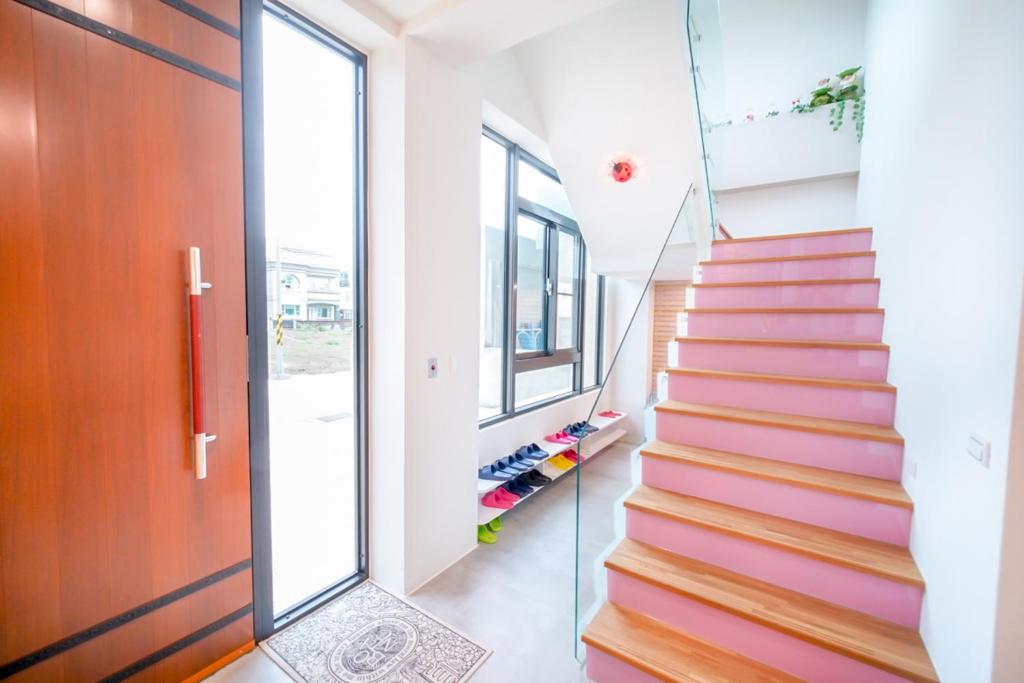 una escalera en una casa con puerta de cristal en Penghu I Stay I, en Magong