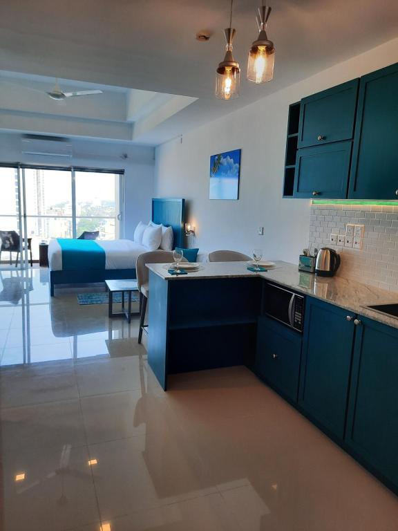 a kitchen with a sink and a bed in a room at Ocean Breeze Aparthotel Negombo R11 B01 in Negombo