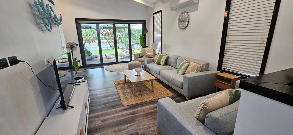 Sala de estar con 2 sofás y mesa en MOOLOOLABA CANAL HOME - Modern 4Bedroom with Spa, Sauna and Private Pontoon - NEW proprietor 2024, en Mooloolaba