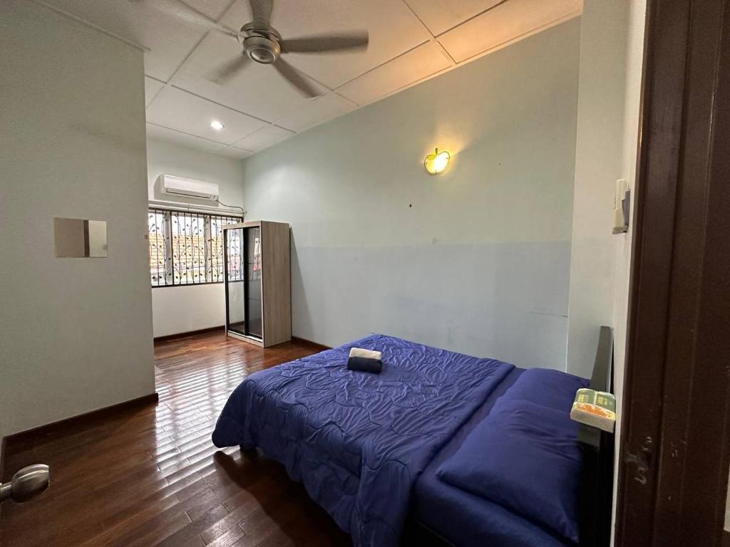 a bedroom with a blue bed and a ceiling fan at Casa Lily Residence IM8 in Kuantan