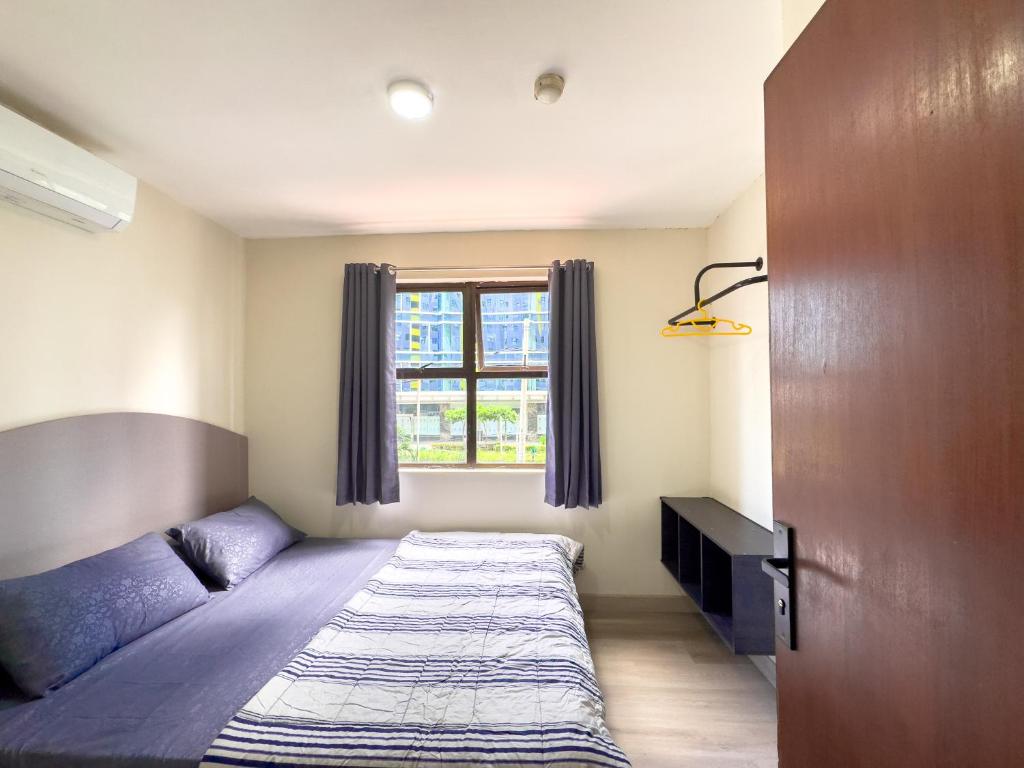 a bedroom with a bed and a window at Beranda Istirahat 2BR Laguna Pluit in Jakarta