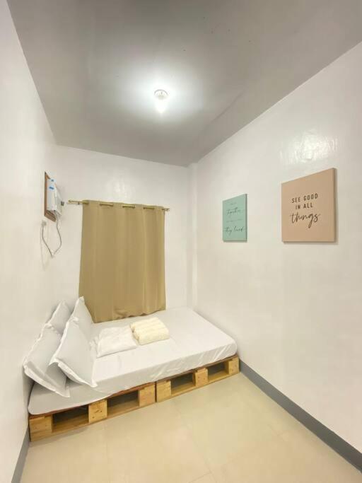 Staycation in Imus Near Robinson في Imus: غرفة بسرير وعلامة على الحائط