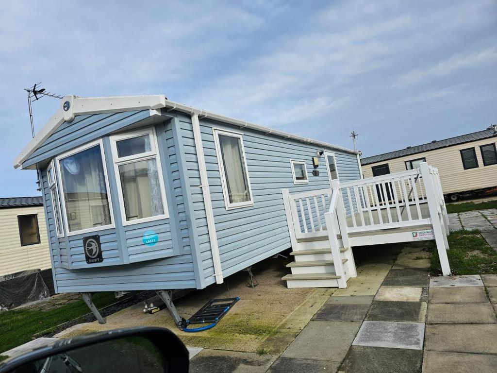 a blue tiny house sitting in a parking lot at 2BEDROOMEVIE in Rhyl