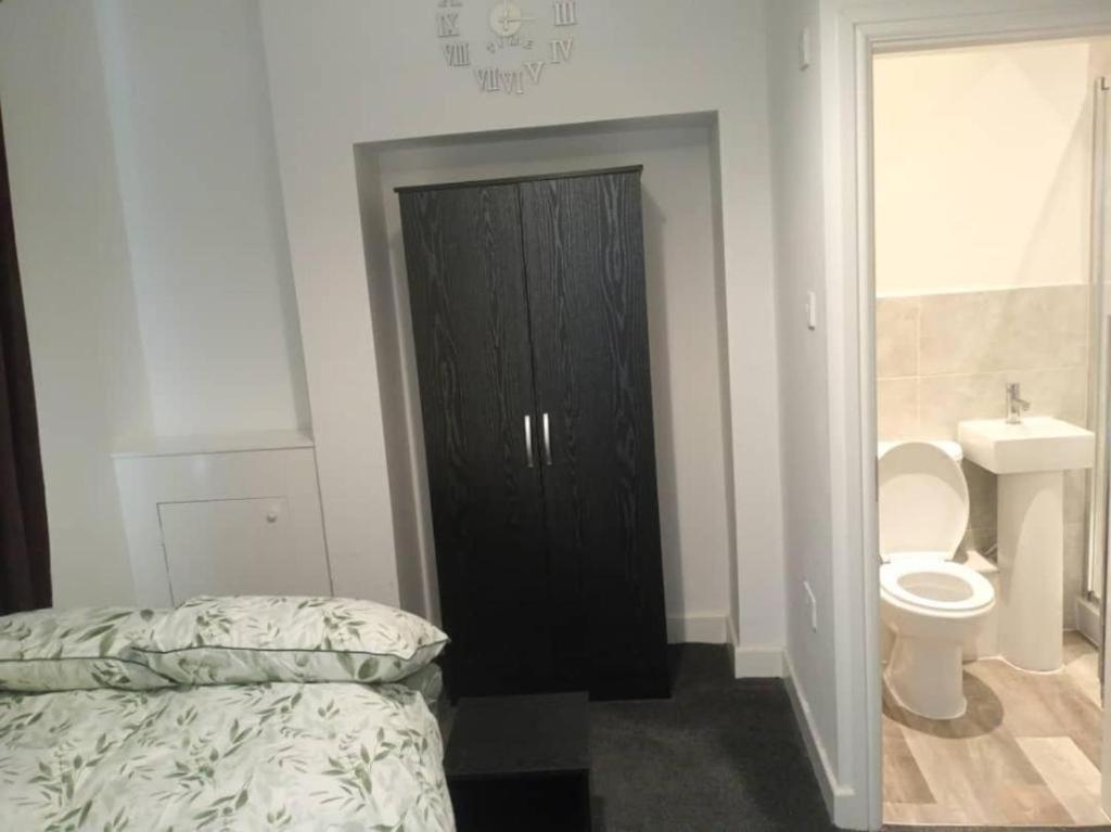 ein Schlafzimmer mit einem Bett und ein Badezimmer mit einem WC in der Unterkunft Ensuite double-bed (G1) close to Burnley city centre in Burnley