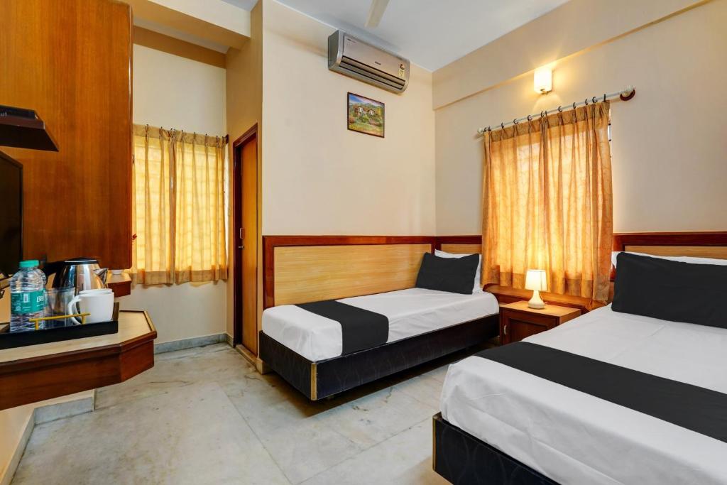 a hotel room with two beds and a window at SPOT ON Benaka Delux Lodging & Delux Rooms in Bangalore