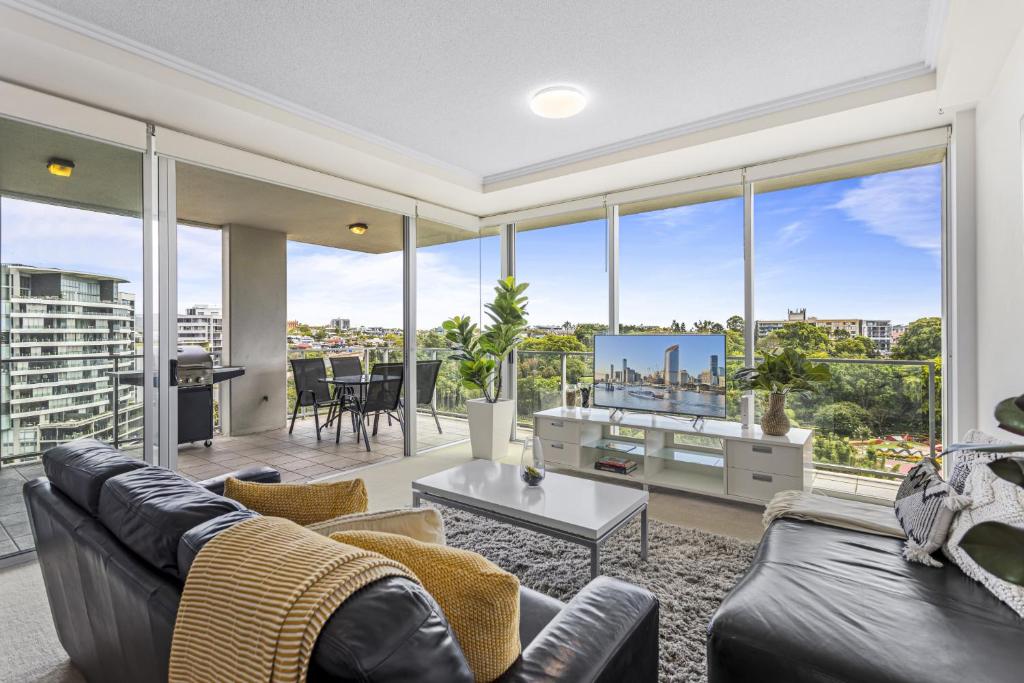 a living room with a couch and a tv at High-Floor 2-Bed CBD Unit With Views & Amenities in Brisbane
