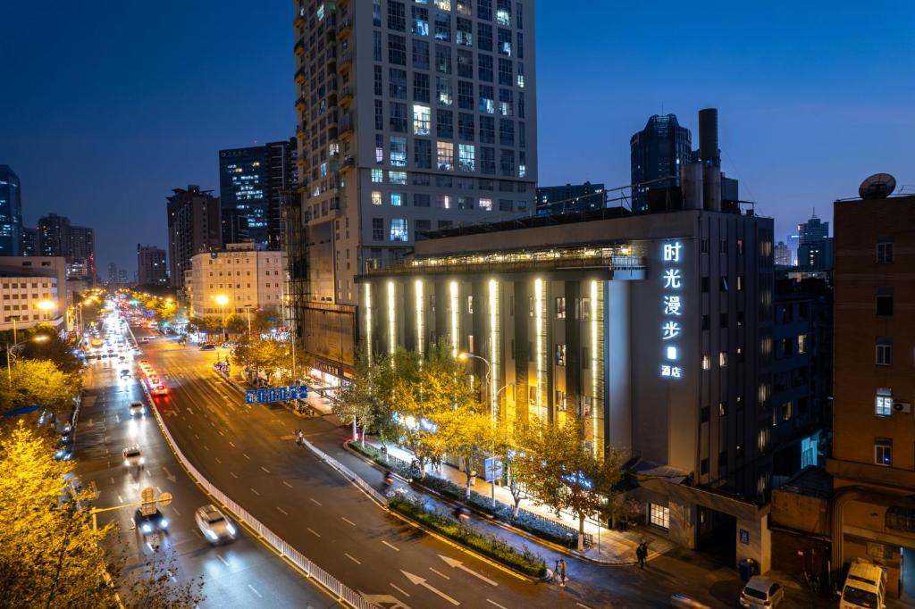 una calle de la ciudad por la noche con edificios y luces en Nostalgia S Hotel - North Railway Station Kunming, en Kunming