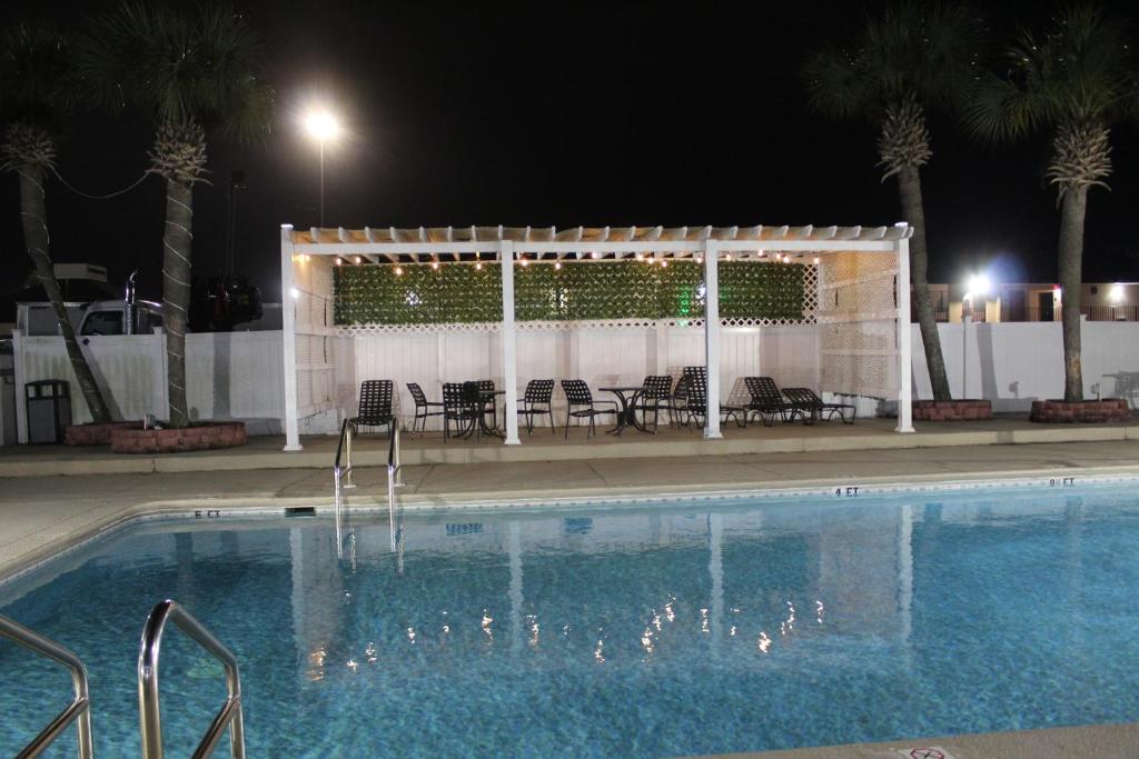 una piscina con sillas y un pabellón por la noche en Days Inn by Wyndham Marianna, en Marianna