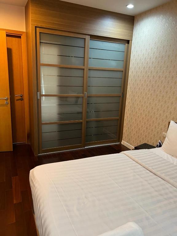 Circle condominium في Makkasan: غرفة نوم مع نافذة زجاجية كبيرة مع سرير