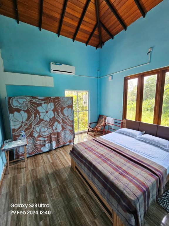 1 dormitorio con 1 cama grande en una habitación azul en Kevin's Place, en Seeduwa