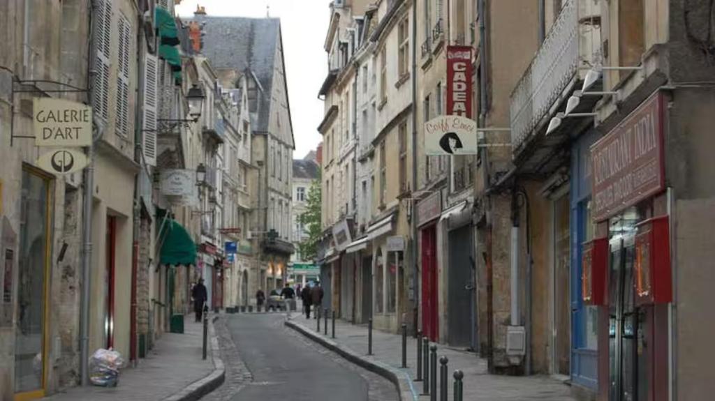 een lege straat met gebouwen en mensen die over straat lopen bij Appartement centre ville Poitiers in Poitiers