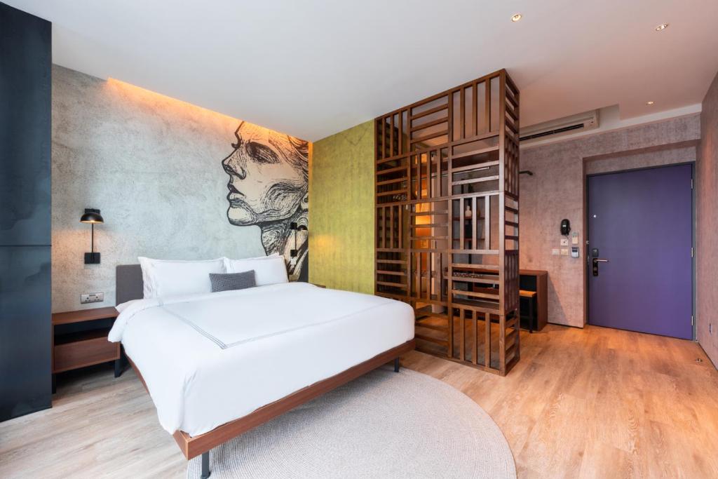 Un dormitorio con una cama blanca y una pintura en la pared en Dash Living on Queen's, en Hong Kong
