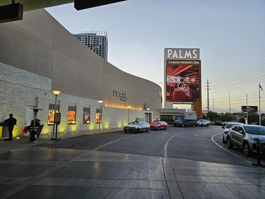 Elegant stay at Palms Strip Las Vegas في لاس فيغاس: موقف للسيارات مع وقوف السيارات أمام المبنى