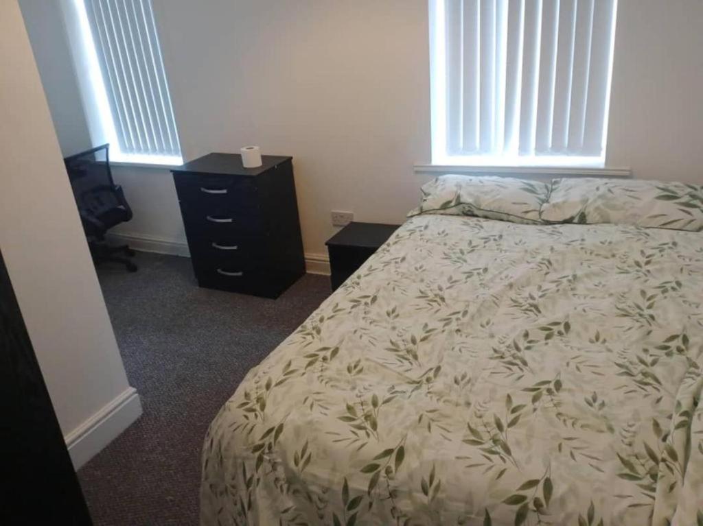 una camera con letto, cassettiera e finestre di Ensuite Double-bed (R3) close to Burnley city centre a Burnley