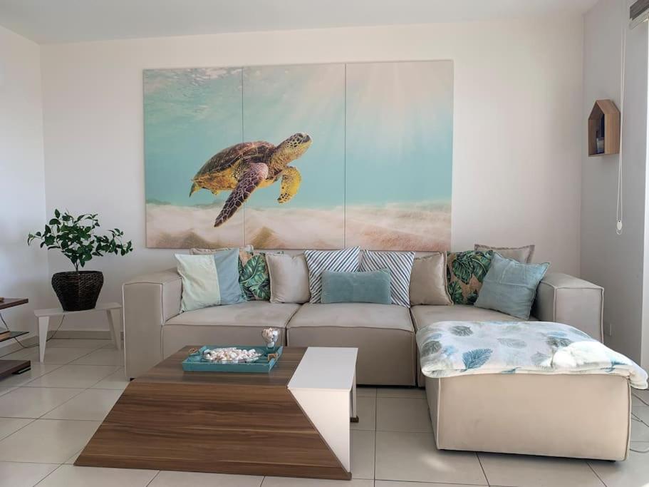 a living room with a couch and a turtle painting at Scenic Sea View 2BR Apartment * 5min to Beach in Alanya