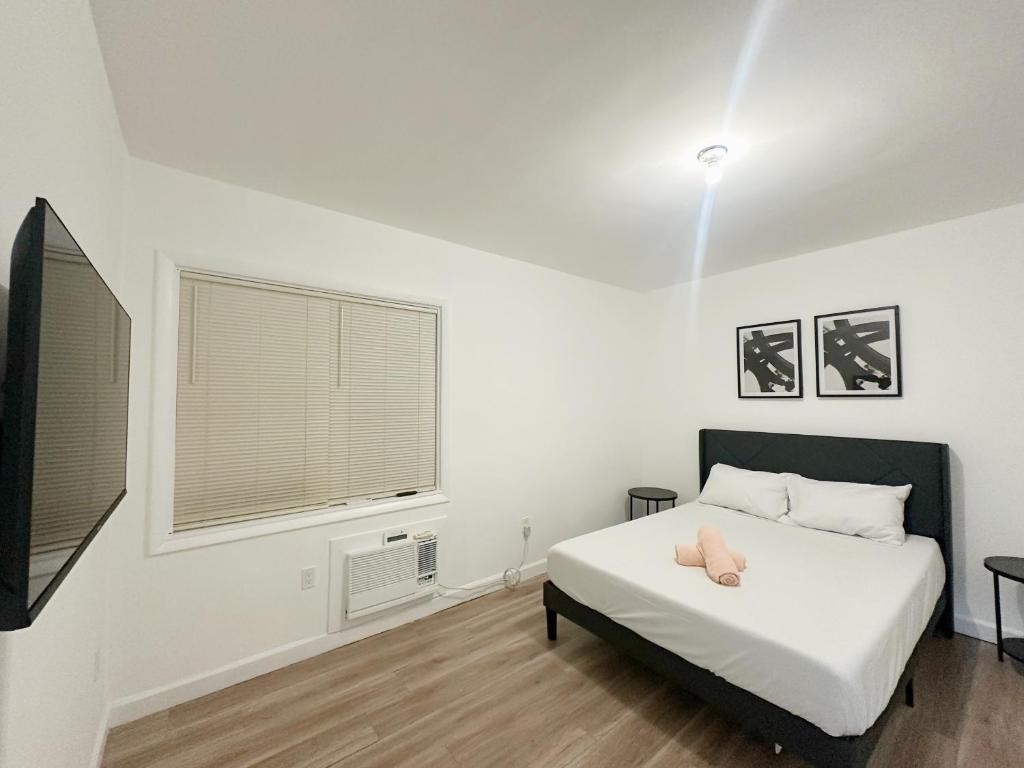 a white bedroom with a bed and a window at 2-BDRM Fort Lauderdale - Las Olas Beach 5 minutes walk #5 in Fort Lauderdale
