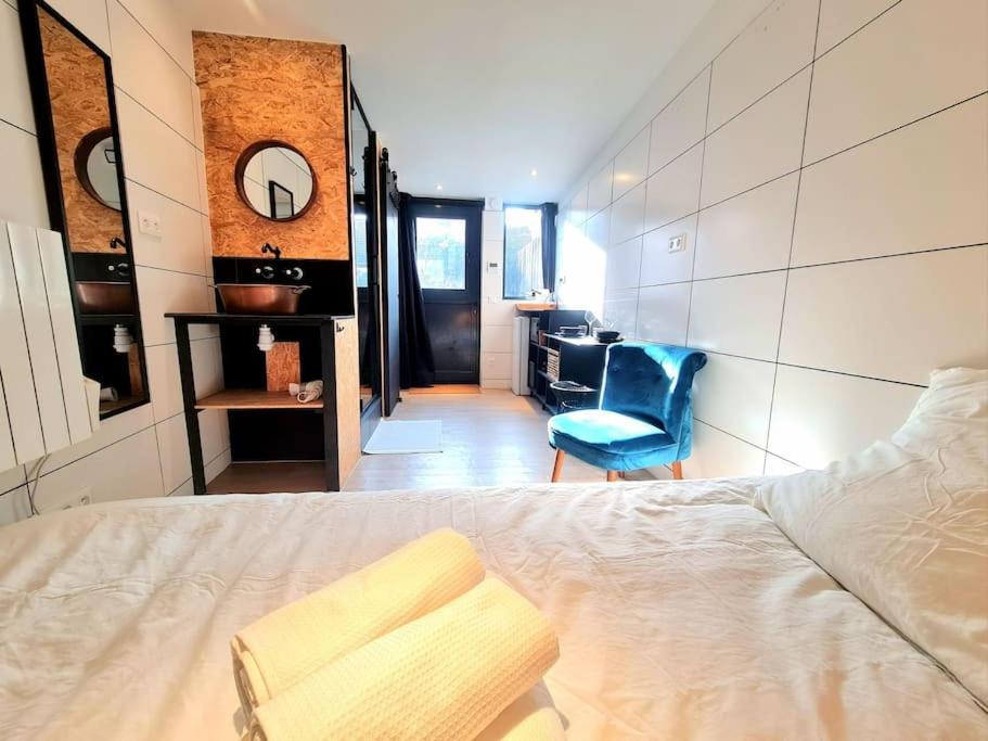 une chambre avec un lit et une chaise bleue dans l'établissement Studio indépendant avec jardin privatif, à Fontenay-aux-Roses