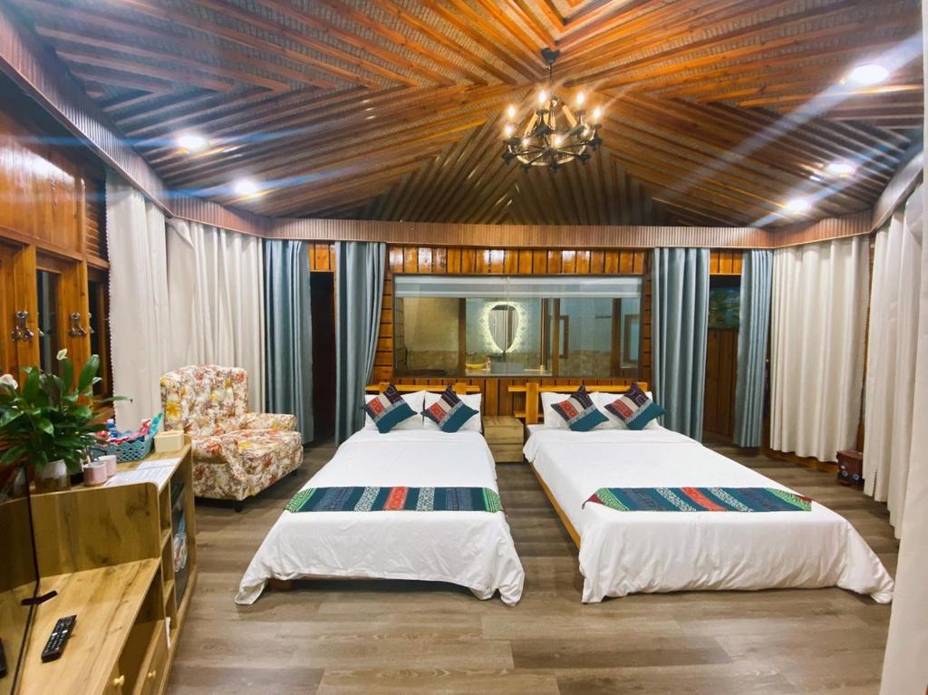 a bedroom with two beds and a couch and a chandelier at SaPa Sinai Homestay in Sa Pa
