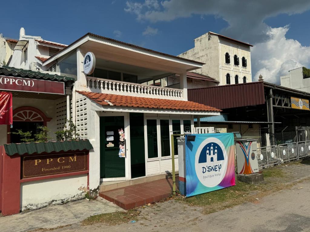 a building with a sign on the side of a street at Dsney Boutique Hotel in Melaka