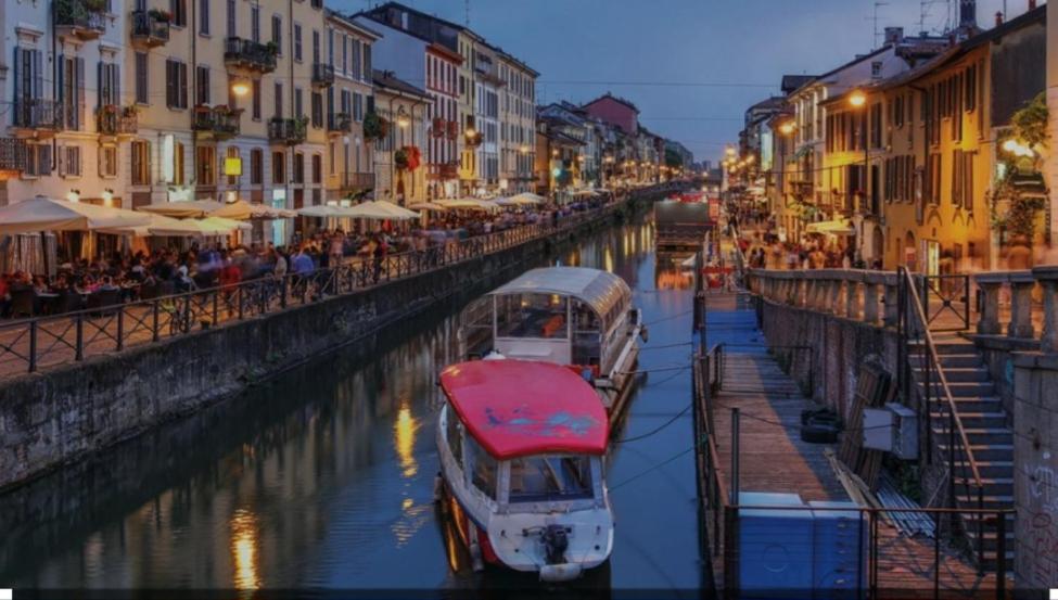 deux bateaux sont amarrés dans un canal d'une ville dans l'établissement heart of milan Apartment, à Milan