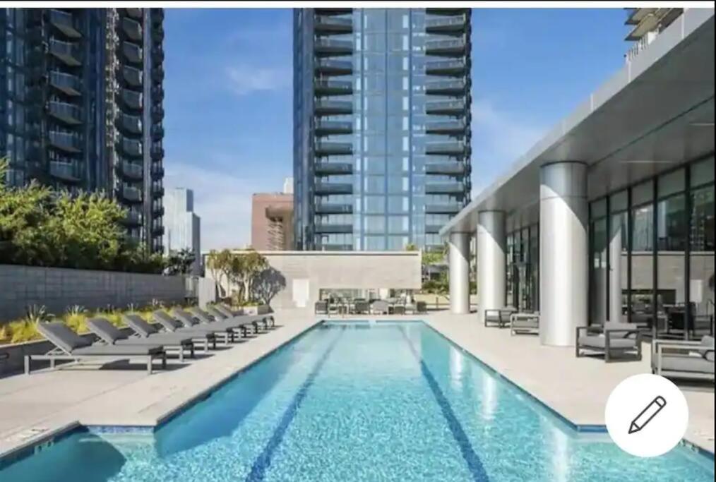 una piscina con sillas y un edificio en Comfy Apt with pool & hot tub in downtown LA', en Los Ángeles