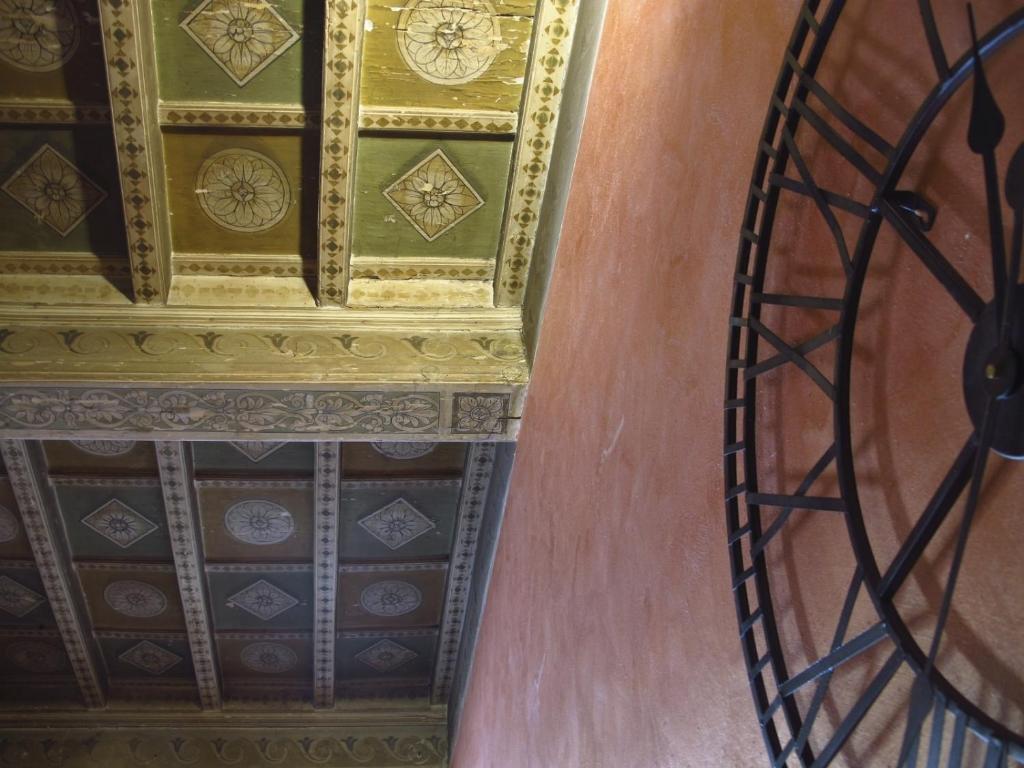Habitación con techo y reloj en la pared en Casa Lorena, en Florencia