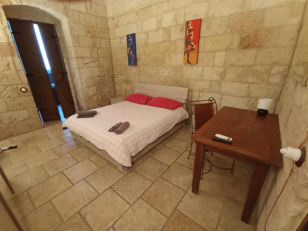 - une chambre avec un lit doté d'oreillers rouges et d'une table dans l'établissement Black Rose, à Bari