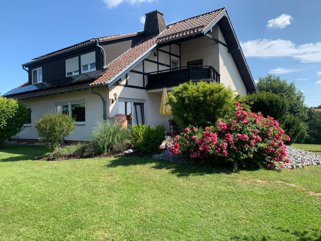a house with flowers in the front yard at Ferienwohnung bei Besten in Sachsenhausen