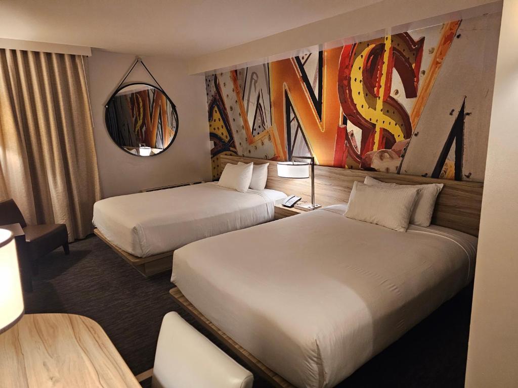 a hotel room with two beds and a mirror at Coolest bar hoping Linq Casino Hotel Strip Las Vegas in Las Vegas