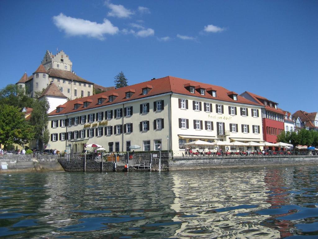 ein großes Gebäude neben einem Wasserkörper in der Unterkunft Flair Hotel zum Schiff in Meersburg