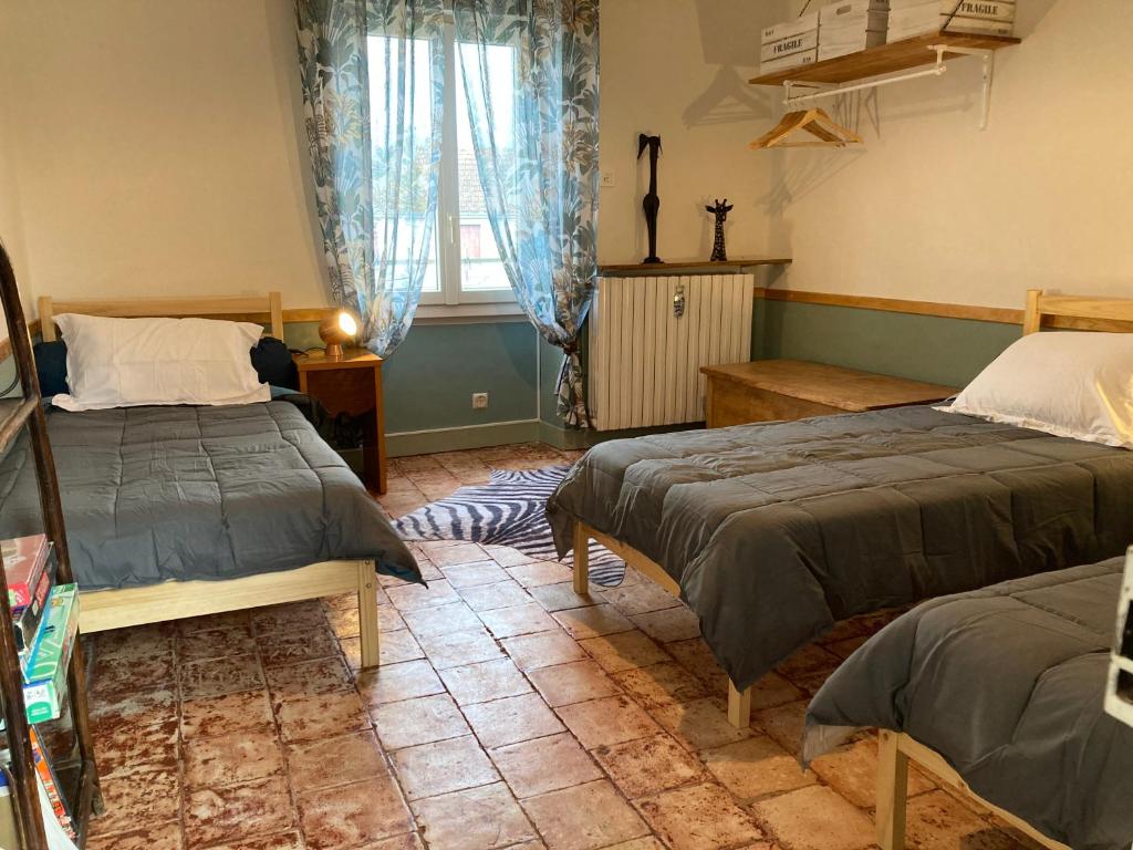 a bedroom with two beds and a window at Coup de cœur en Brenne in Martizay