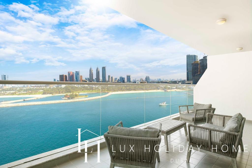 a balcony with chairs and a view of the water at LUX - Opulent Island Suite 3 in Dubai