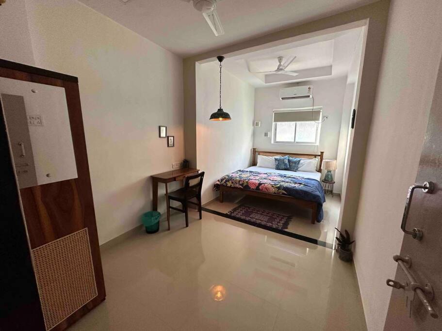 a bedroom with a bed and a table in it at Bombay Basti 3 Waroda Road Veronica's Bandra W in Mumbai